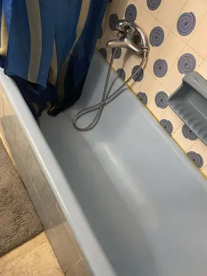a bath tub with a hose attached to a shower curtain at Spyros apartment 2 in Athens