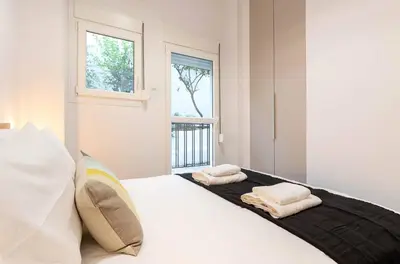a bedroom with a bed with two towels on it at 2 Bedroom Apt with Secret Garden In The heart Of Athens in Athens