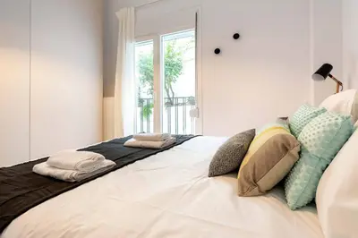 a bedroom with a large bed with pillows on it at 2 Bedroom Apt with Secret Garden In The heart Of Athens in Athens