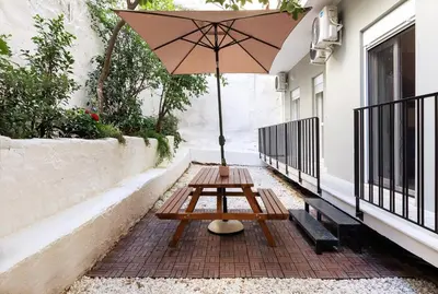 a picnic table with an umbrella on a patio at 2 Bedroom Apt with Secret Garden In The heart Of Athens in Athens