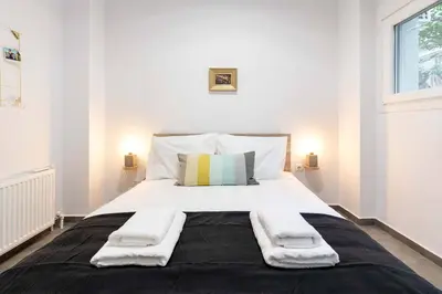 a bedroom with a large bed with towels on it at 2 Bedroom Apt with Secret Garden In The heart Of Athens in Athens