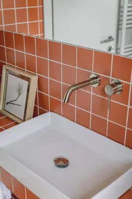 a bathroom sink with a faucet and a picture at Stylish cozy artistic Athens apartment in Athens