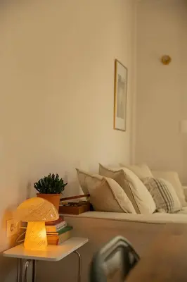 a bed in a room with a table with books at Stylish cozy artistic Athens apartment in Athens