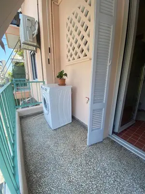 a washing machine sitting on a porch next to a door at Stylish cozy artistic Athens apartment in Athens