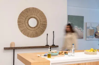 a woman walking in a kitchen with a plate of food at My Happy Greek Home in Athens