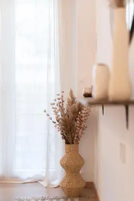 a vase with flowers sitting on a table next to a window at My Happy Greek Home in Athens