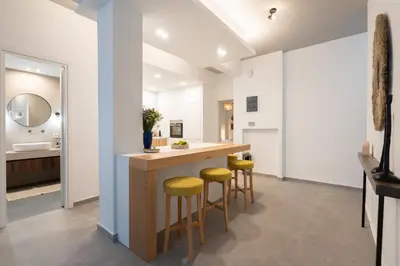 a kitchen with a counter with yellow stools at My Happy Greek Home in Athens