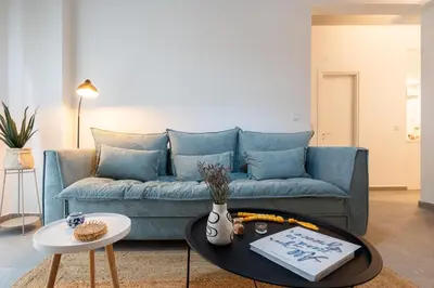 a living room with a blue couch and a table at My Happy Greek Home in Athens