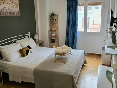 a bedroom with a large bed with a chair on it at Apollonas in Athens