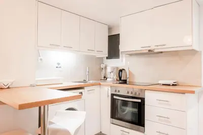 a white kitchen with white cabinets and a sink at Galini in Athens