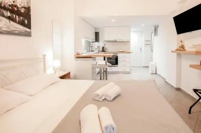 a white bedroom with two towels on a bed at Galini in Athens
