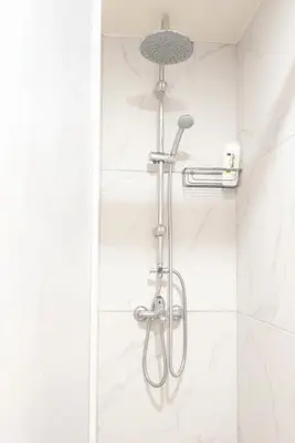 a shower in a bathroom with white tiles at Galini in Athens