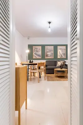 a living room with a couch and a table at Zen Vouliagmeni Beach Apartment in Athens