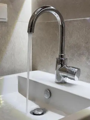 a sink with water coming out of a faucet at Zen Vouliagmeni Beach Apartment in Athens