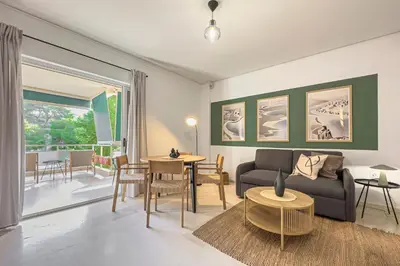 a living room with a couch and a table at Zen Vouliagmeni Beach Apartment in Athens
