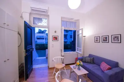 a living room with a blue couch and a table at Garden-studio in a mansion-Athens-Chalandri center in Athens