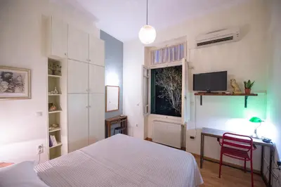 a bedroom with a bed and a desk and a television at Garden-studio in a mansion-Athens-Chalandri center in Athens