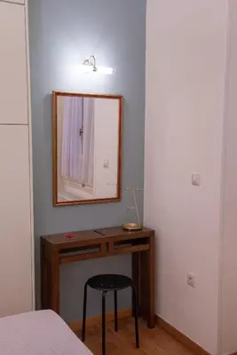 a bedroom with a desk with a mirror and a stool at Garden-studio in a mansion-Athens-Chalandri center in Athens