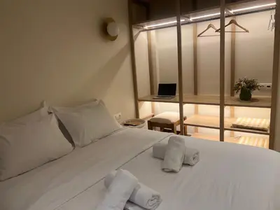 a bedroom with a white bed with towels on it at Athens Ilisiam in Athens