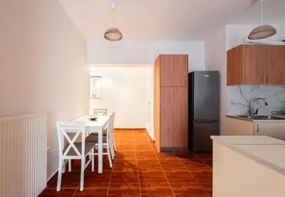 a kitchen with a table and chairs and a refrigerator at Erechthiou 15 Koukaki Apartment by Athens Concept Residences in Athens