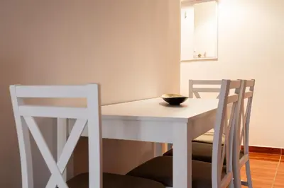 a white dining room table with two chairs and a bowl on it at Erechthiou 15 Koukaki Apartment by Athens Concept Residences in Athens