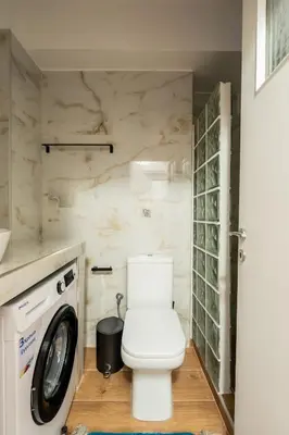 a bathroom with a toilet and a washer at Erechthiou 15 Koukaki Apartment by Athens Concept Residences in Athens