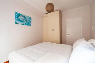 a white bedroom with two beds and a cabinet at Erechthiou 15 Koukaki Apartment by Athens Concept Residences in Athens