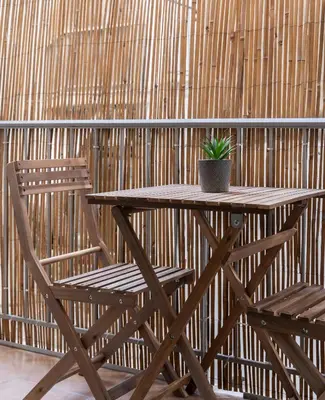 a wooden table and chair with a potted plant on it at Erechthiou 15 Koukaki Apartment by Athens Concept Residences in Athens