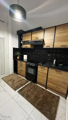 a kitchen with wooden cabinets and a black counter top at LIttLE PARADISE in Athens