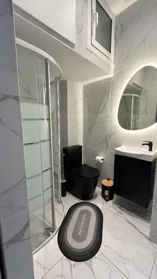 a bathroom with a black toilet and a sink at LIttLE PARADISE in Athens