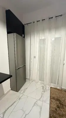 an empty kitchen with a refrigerator and white curtains at LIttLE PARADISE in Athens