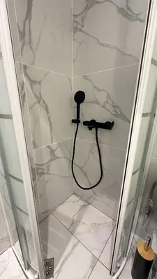 a shower with a black hose in a shower stall at LIttLE PARADISE in Athens