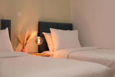 a bedroom with two beds and a lamp on a table at Psirri Urban Chic in Athens