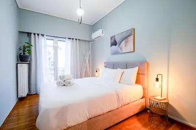 a bedroom with a large white bed and a window at The Parthenon Porch for Familys & Groups , 4BR ! in Athens