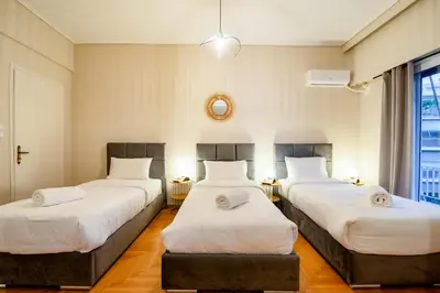three beds in a room with white sheets at The Parthenon Porch for Familys & Groups , 4BR ! in Athens