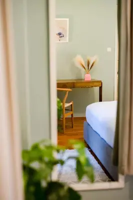 a bedroom with a bed and a desk with a plant at The Parthenon Porch for Familys & Groups , 4BR ! in Athens