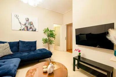 a living room with a blue couch and a table at The Parthenon Porch for Familys & Groups , 4BR ! in Athens