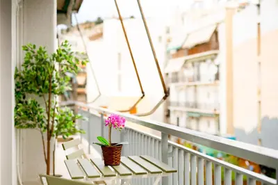 a balcony with two chairs and a flower in a basket at The Parthenon Porch for Familys & Groups , 4BR ! in Athens