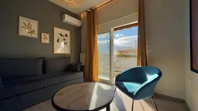 a living room with a couch and a table and a window at Nicolas Home in Athens