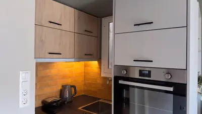 a kitchen with white cabinets and a stove top oven at Nicolas Home in Athens