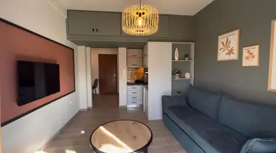 a living room with a blue couch and a table at Nicolas Home in Athens