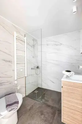 a bathroom with a toilet and a glass shower at 2br Apt Near Ancient Stadium MK in Athens
