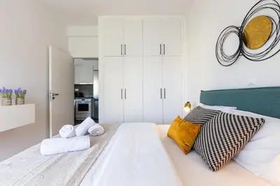 a white bedroom with a large bed with towels at 2br Apt Near Ancient Stadium MK in Athens