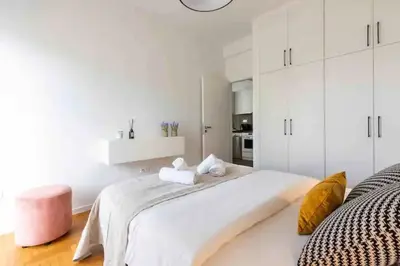 a white bedroom with a large bed with two towels at 2br Apt Near Ancient Stadium MK in Athens