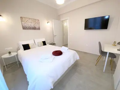 a bedroom with a large white bed and a desk at MediTerra Stay Athens City Center in Athens