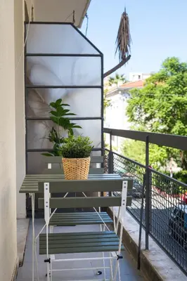 a bench on a balcony with a potted plant at MediTerra Stay Athens City Center in Athens