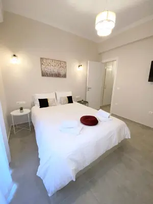 a bedroom with a large white bed with towels on it at MediTerra Stay Athens City Center in Athens