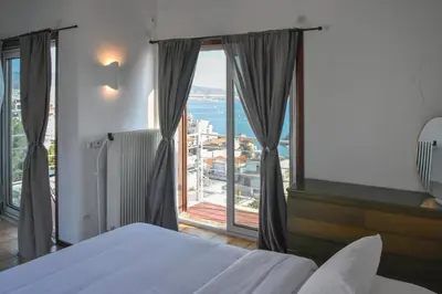a bedroom with a bed and a large window at Modern Apartment with Stunning Piraeus Views in Piraeus