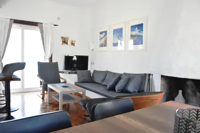 a living room with a couch and a tv at Modern Apartment with Stunning Piraeus Views in Piraeus