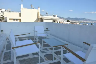 a group of chairs and tables on a roof at Modern Apartment with Stunning Piraeus Views in Piraeus